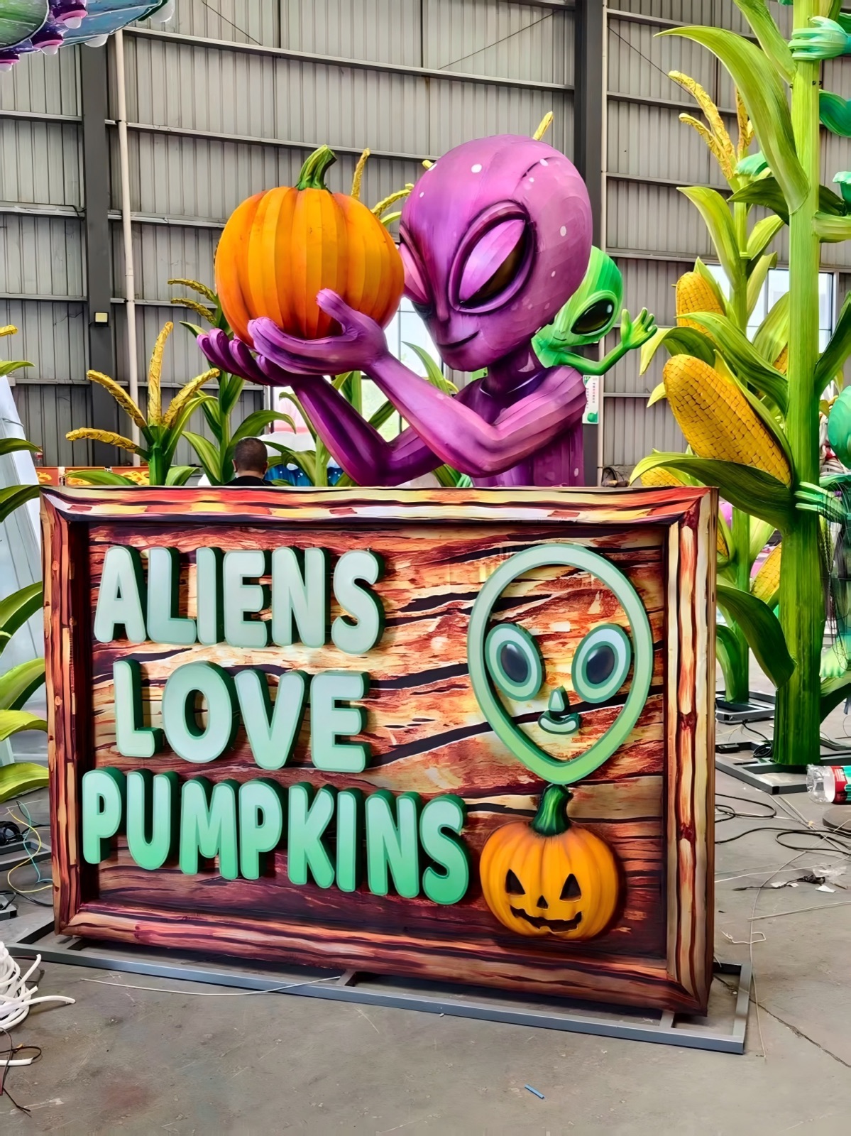 A whimsical aliens love pumpkins lantern sign glowing at night