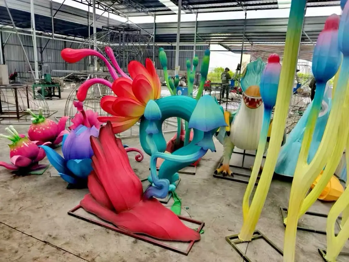 Giant flower and mushroom lantern pieces in production on the workshop floor before installation