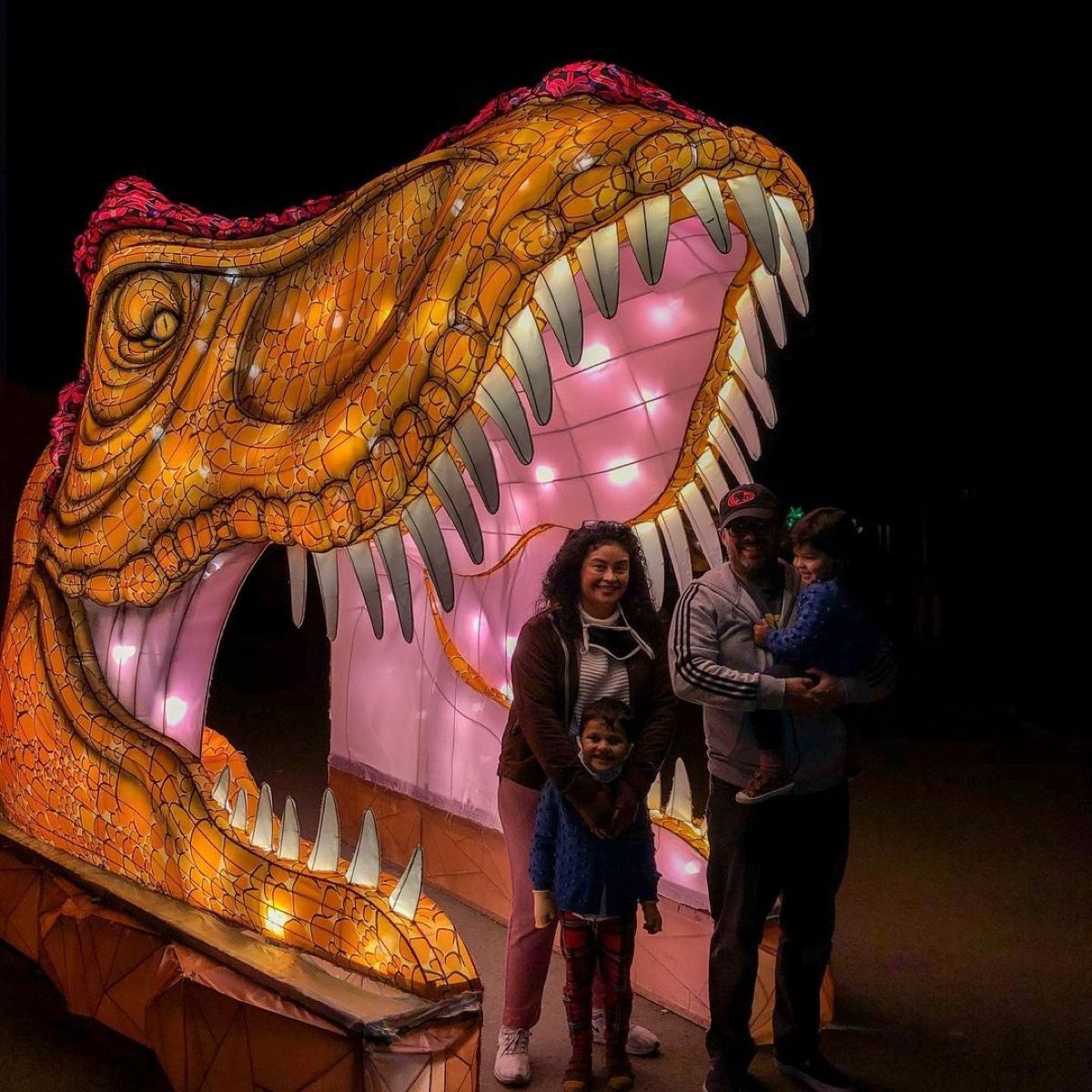 Giant T-rex dinosaur lantern with visitors under its jaws