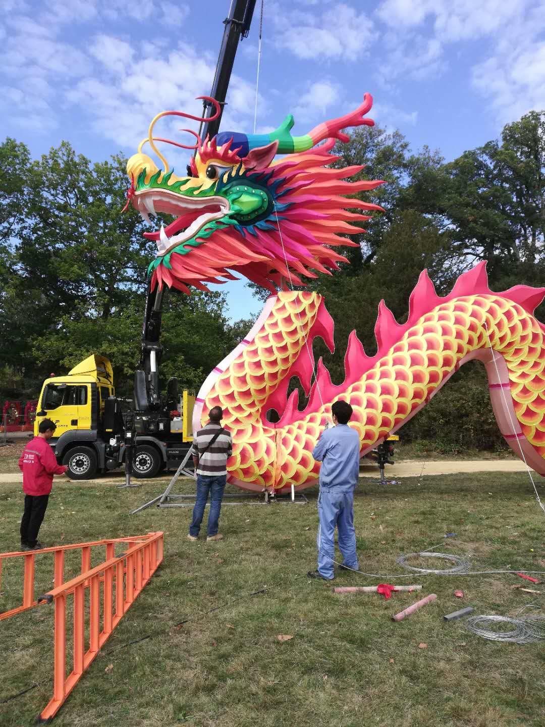 Giant dragon lantern being lifted by crane during overnight installation