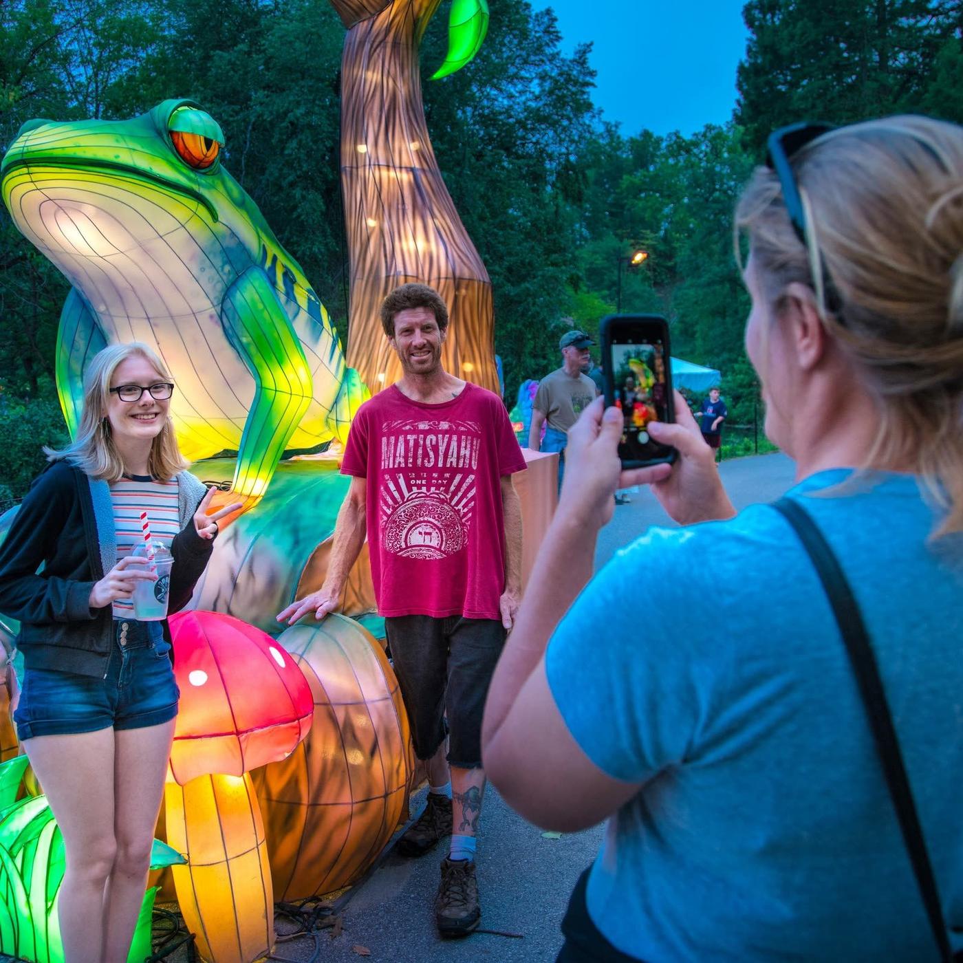 Giant green frog lantern with visitors at immersive night event