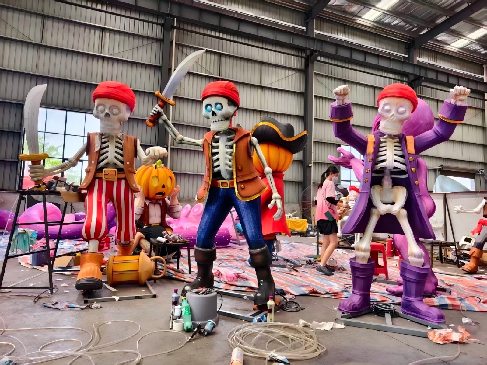 Craftsman airbrush-painting a giant skeleton pirate lantern inside our 5,000 m2 Zigong workshop