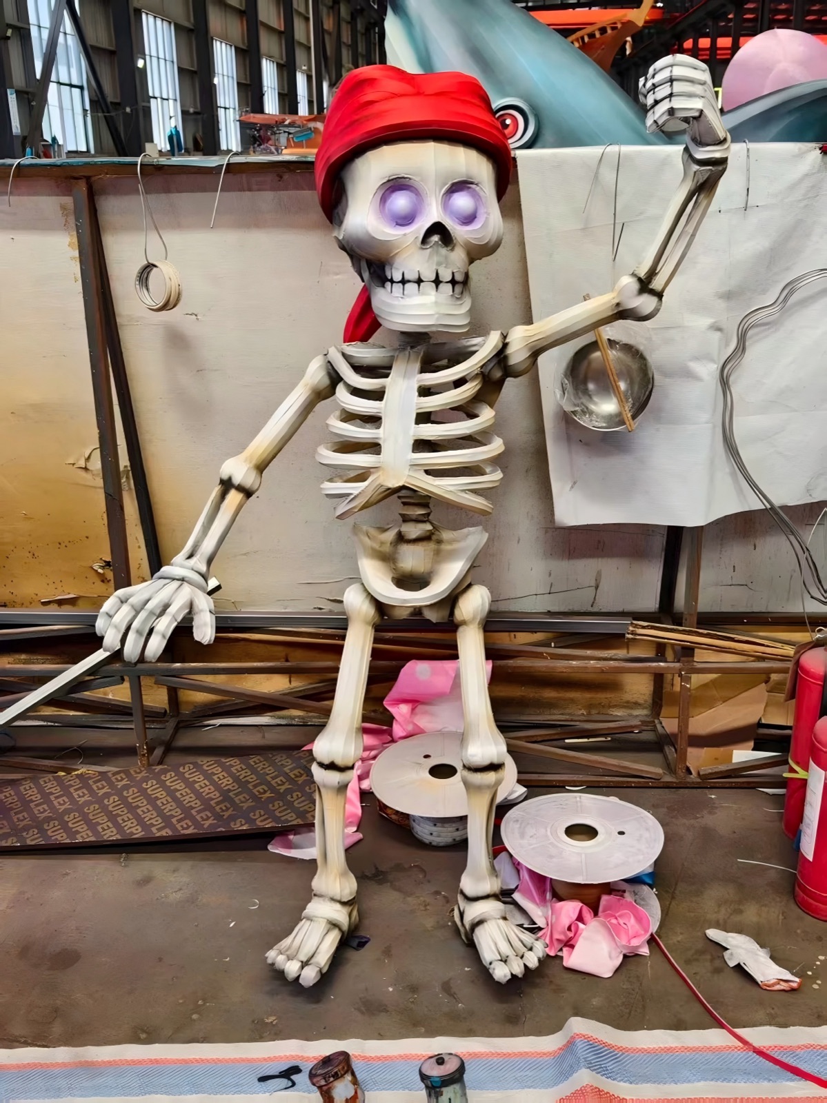 Craftsman airbrush-painting a giant skeleton pirate lantern inside our 5,000 m2 Zigong workshop