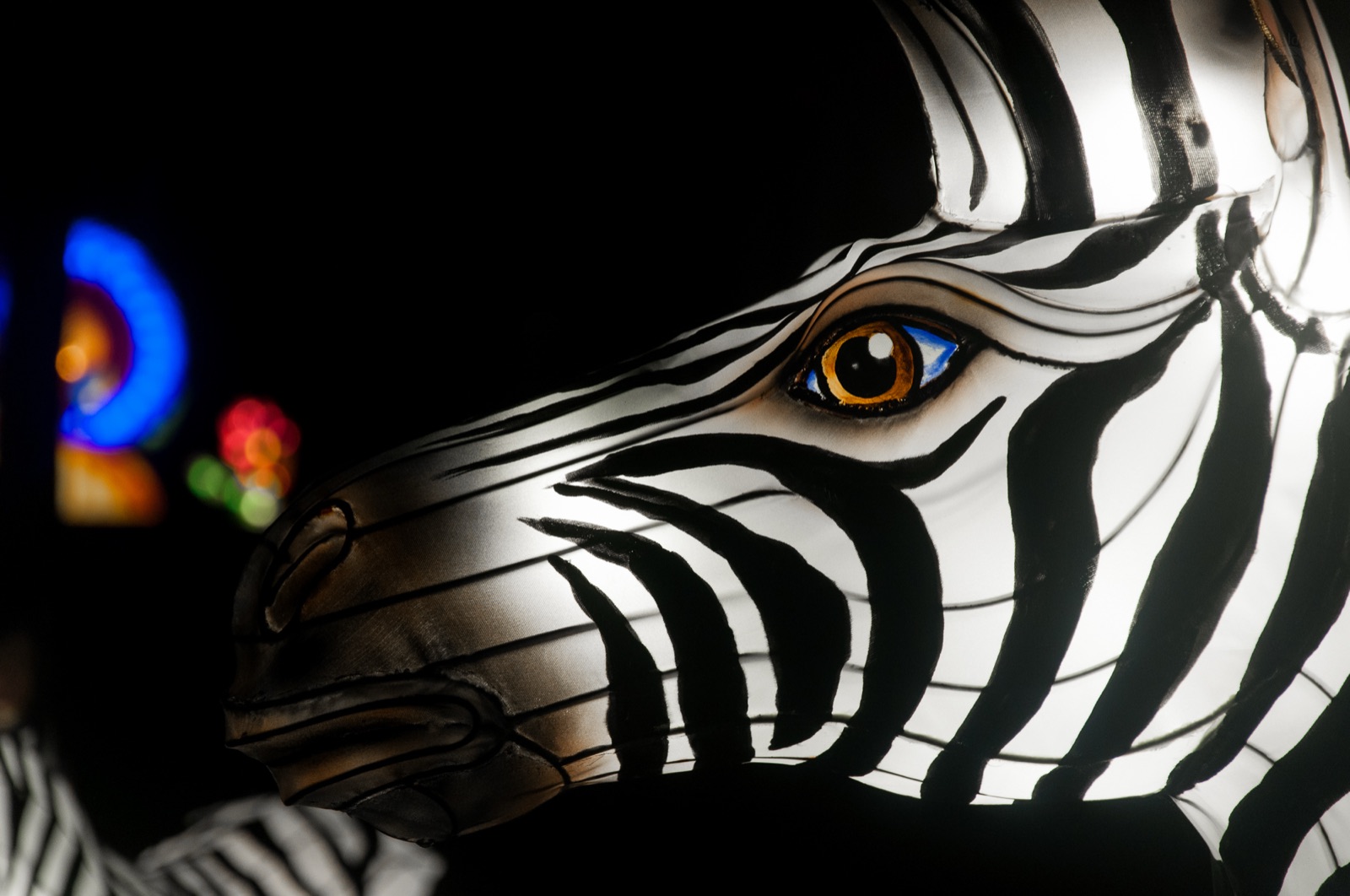 Close-up of a glowing zebra lantern at night with hand-painted stripes and silk skin
